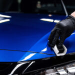 Detailer applying ceramic coating to glossy blue paint