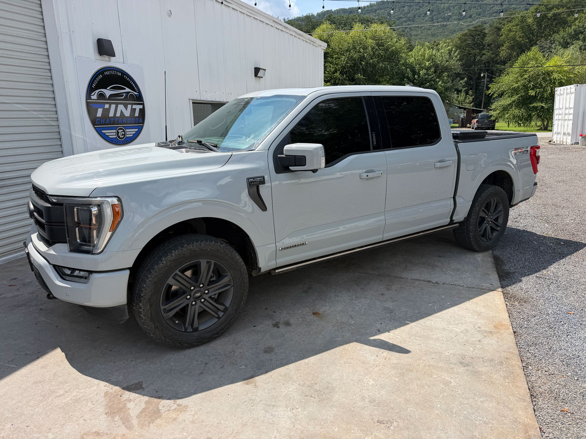 White pickup truck with window tint outside the studio