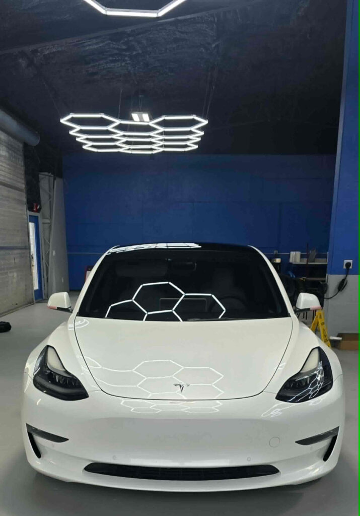 White Tesla under hexagon studio lights
