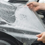 Paint protection film being applied to a vehicle
