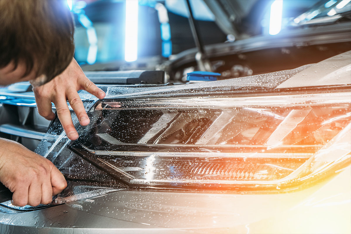 Installer squeegeeing paint protection film onto a vehicle