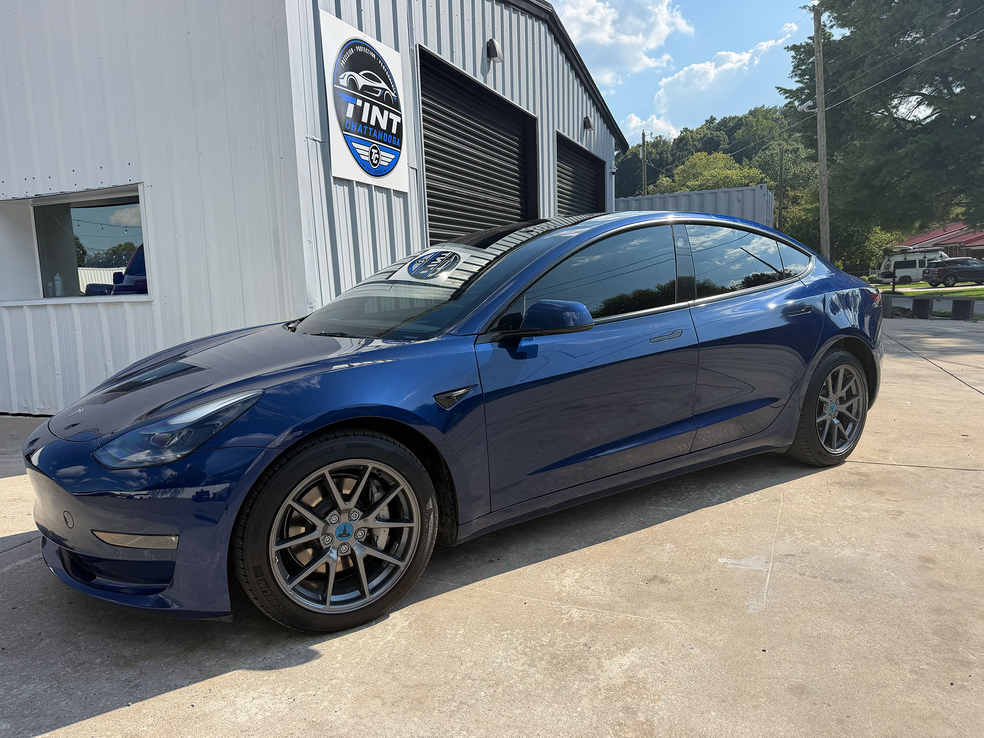 Blue sedan with window tint outside the Tint Chattanooga studio